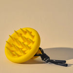 SCALP MASSAGER amarillo con mango ergonómico y cerdas de silicona, ideal para cuidado capilar y estimulación del cuero cabelludo.